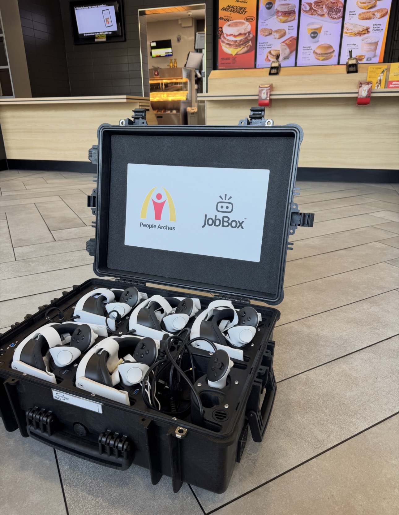 The People Arches JobBox VR recruitment experience open on the floor of a McDonald's restaurant with six Meta Quest 3 headsets inside