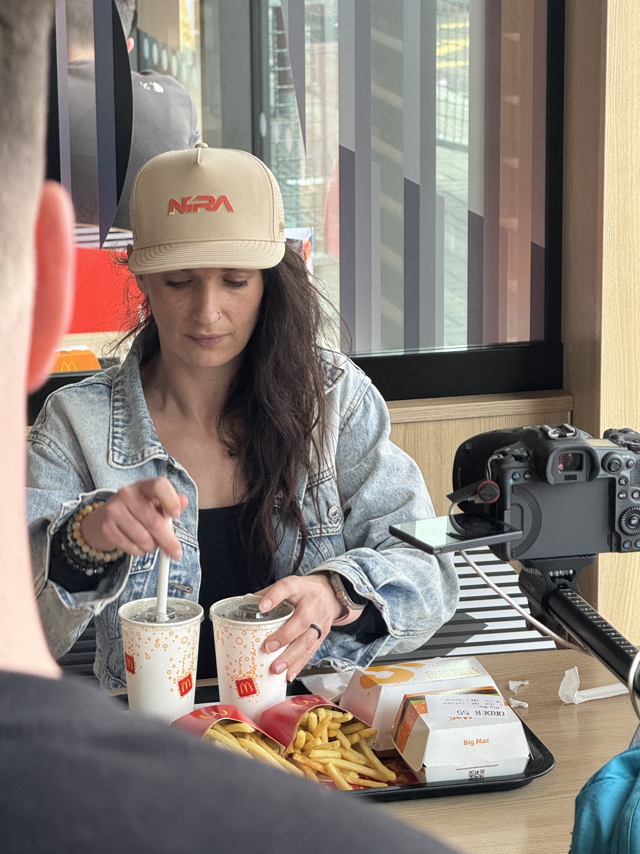 A scene being filmed at a restaurant table with a tray of food and drinks