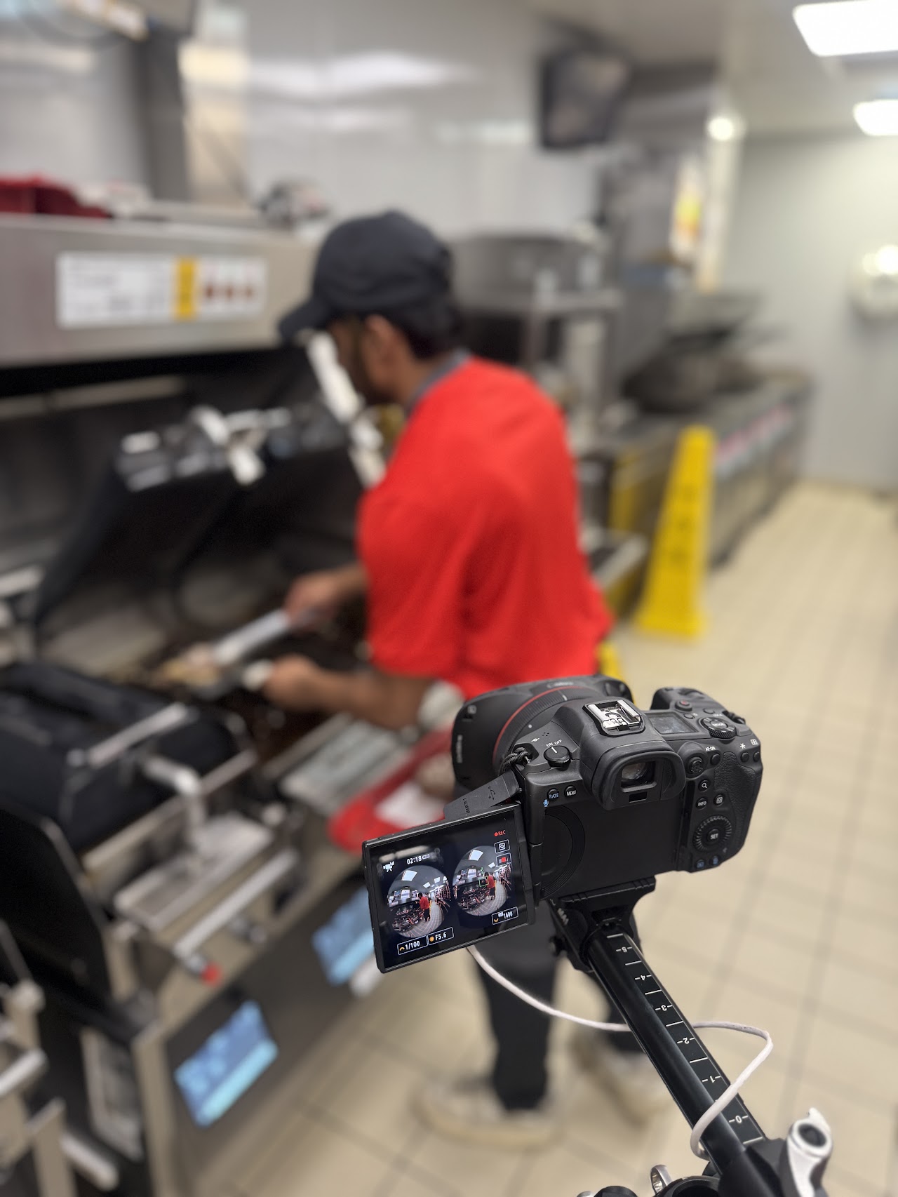 Camera monitor showing the dual fisheye image of a crew member working the kitchen line