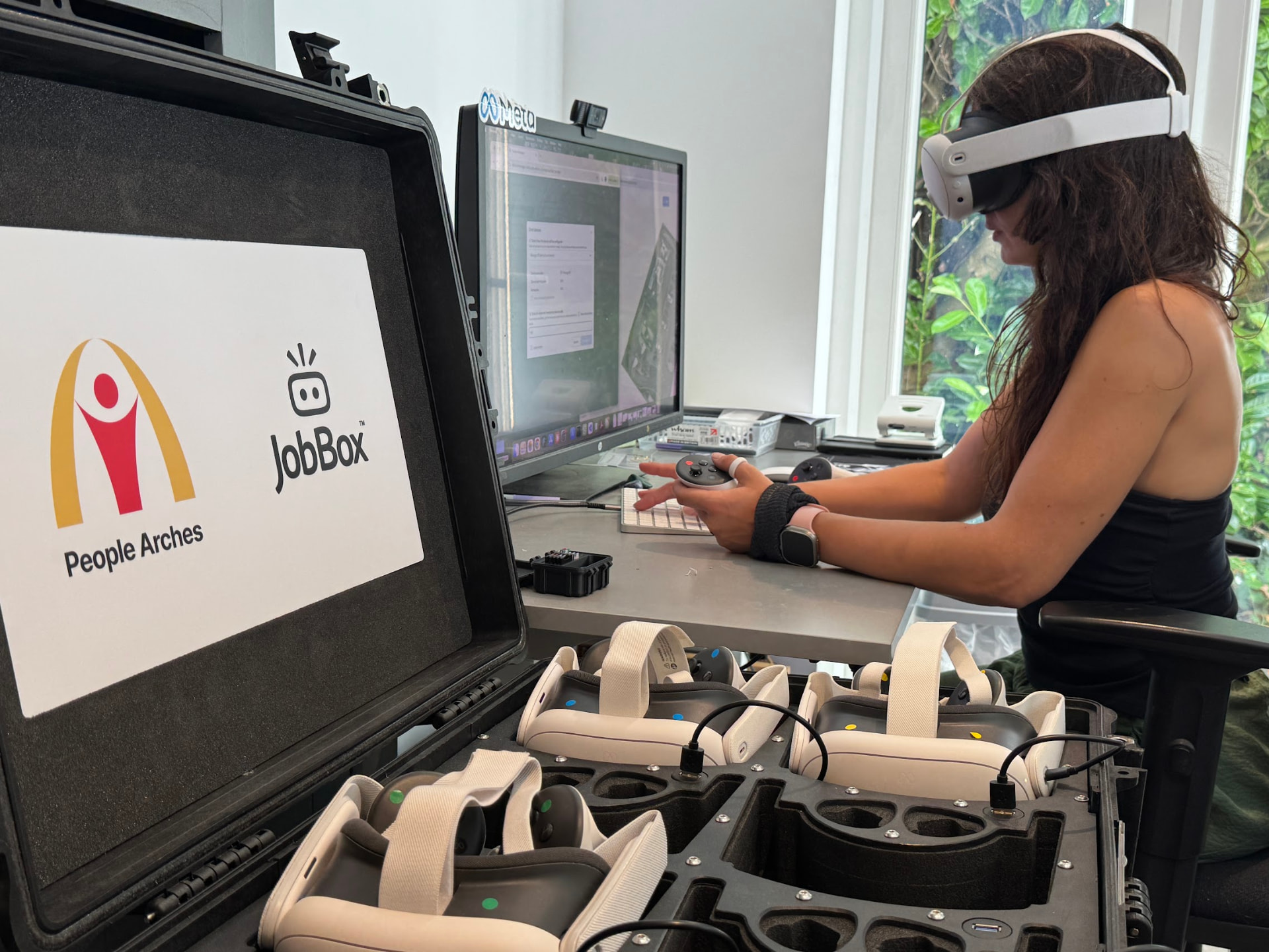 Laura Harvey testing a JobBox VR experience at her desk next to the branded People Arches JobBox case